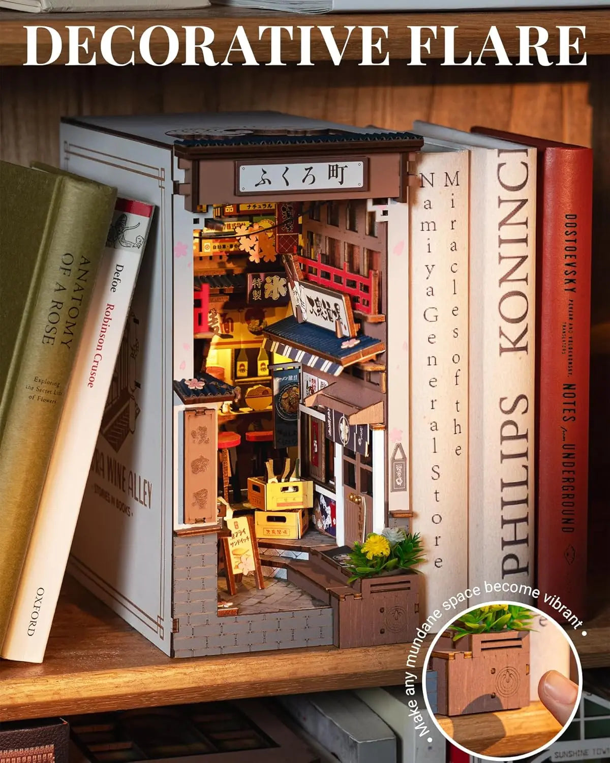 A completed Robotime Sakura Wine Alley Book Nook glowing with warm LED lights between books on a shelf, showing a detailed Japanese miniature street.