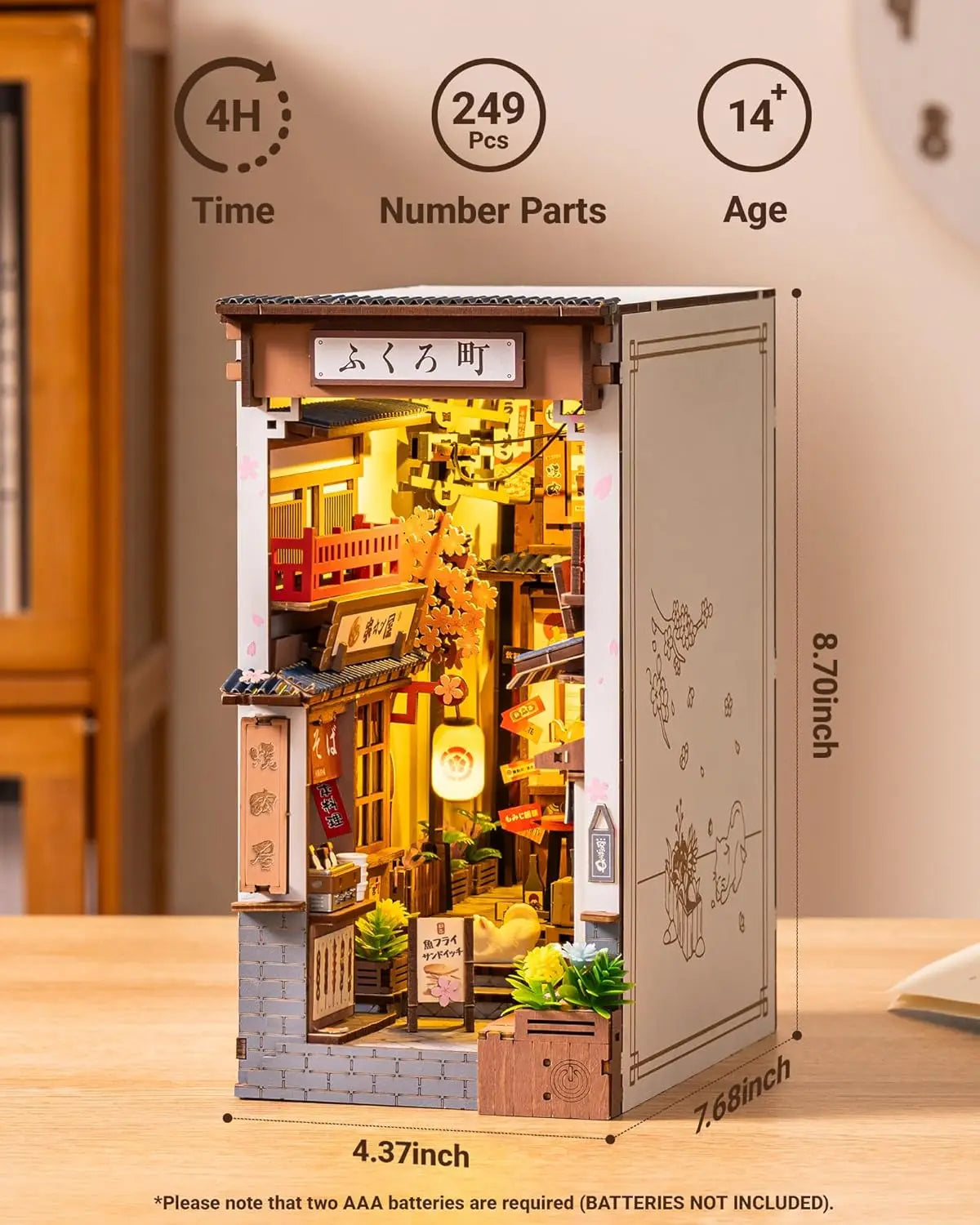 A completed Robotime Sakura Wine Alley Book Nook glowing with warm LED lights between books on a shelf, showing a detailed Japanese miniature street.