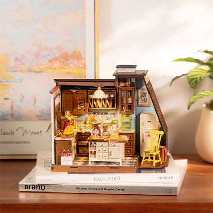 A fully assembled Rolife Baking Kitchen miniature house showing a vintage yellow chair, open oven with bread, and a glowing floral pendant lamp.