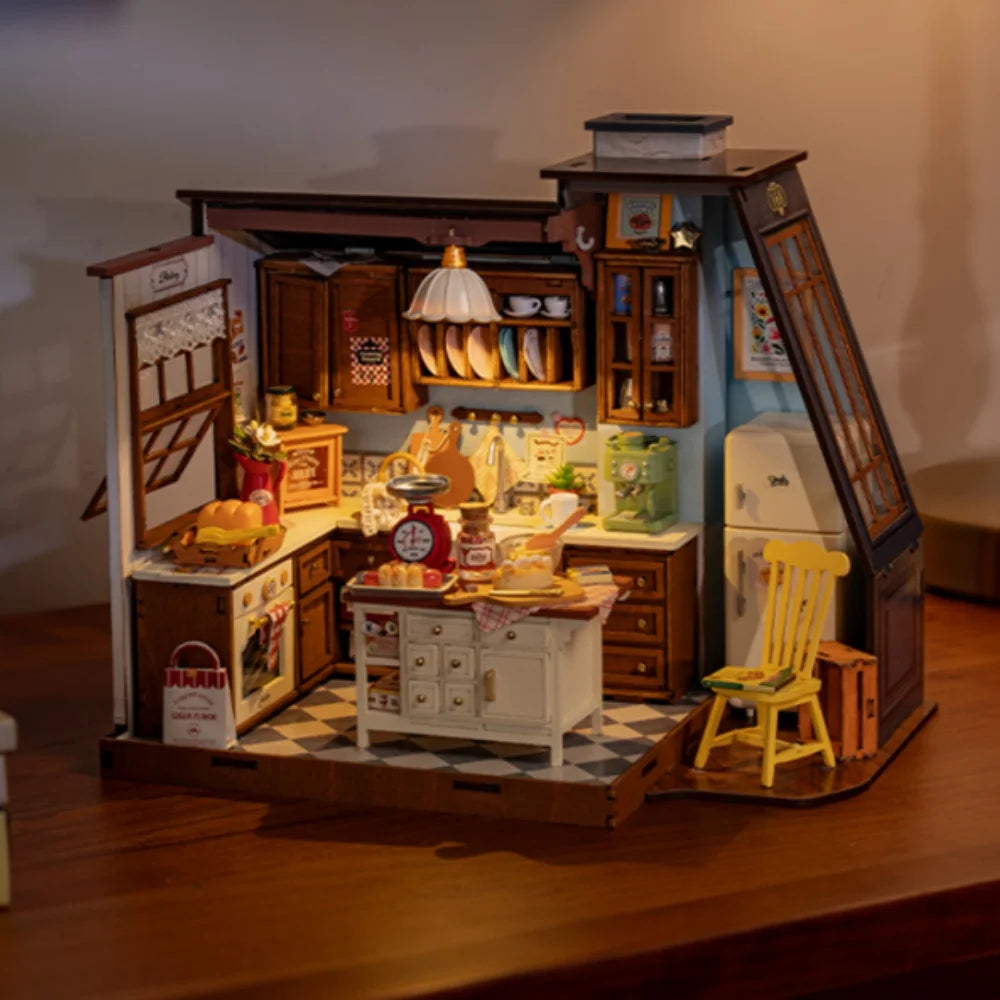 A fully assembled Rolife Baking Kitchen miniature house showing a vintage yellow chair, open oven with bread, and a glowing floral pendant lamp.